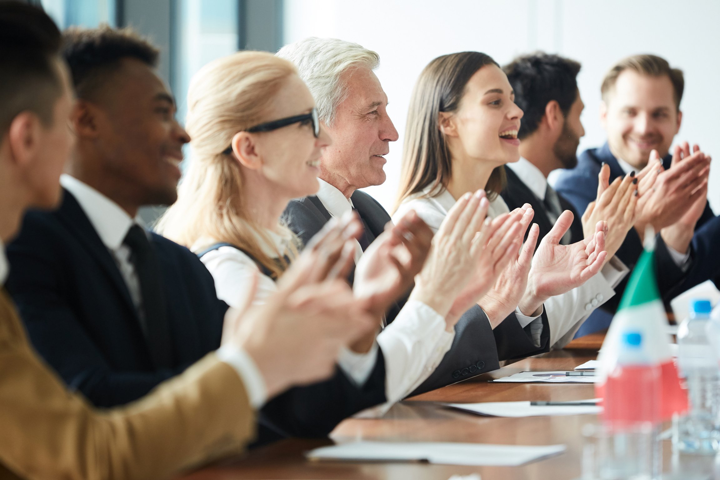 Excited government representatives applauding after meeting